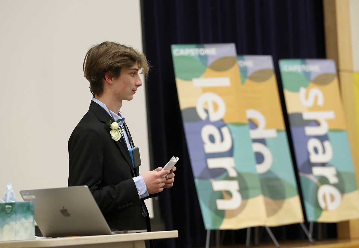 Learn. Do. Share. An eighth grader presents his Capstone