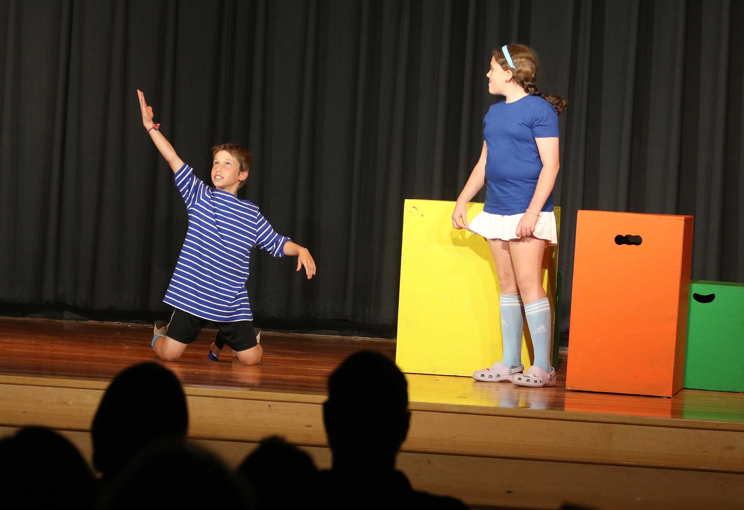 Two students in dramatic poses on stage